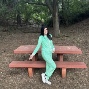 A photo of Hill in the park wearing our Microraptor Women's Velvet Drawstring Pants in Vibrant Green