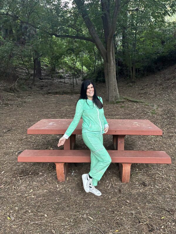 A photo of Hill in the park wearing our Microraptor Women's Velvet Drawstring Pants in Vibrant Green